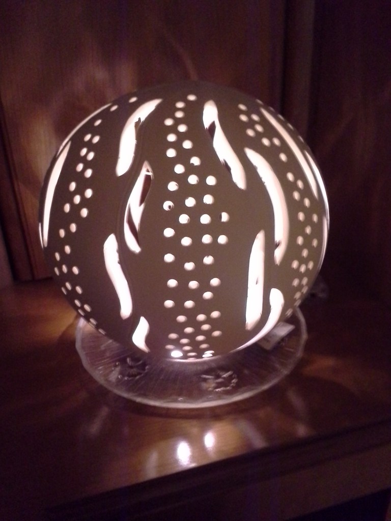 Eine beleuchtete Kugel aus geschnitztem Ton, die als Lampe verwendet werden kann